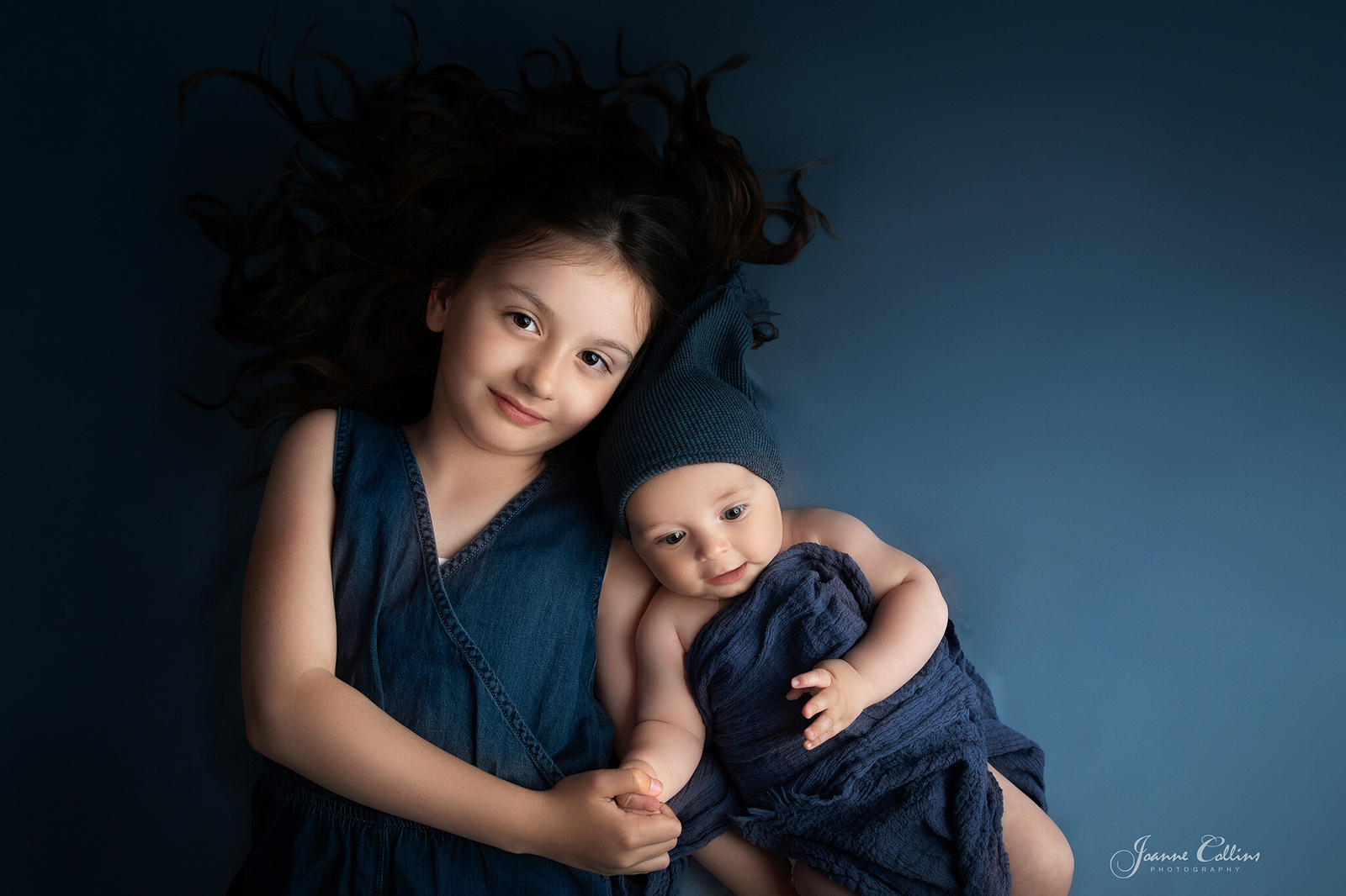 siblings photoshoot kent 8 year girl an 4 month baby on blue